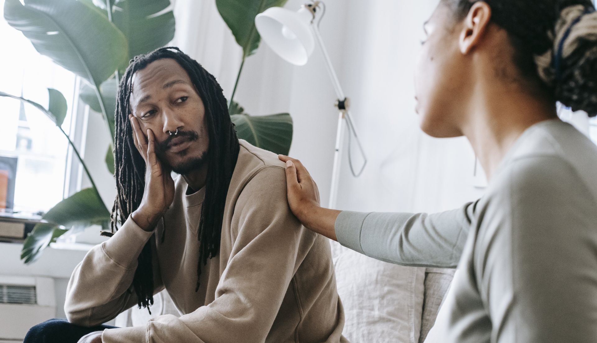 Ethnic psychologist touching black depressed clients shoulder